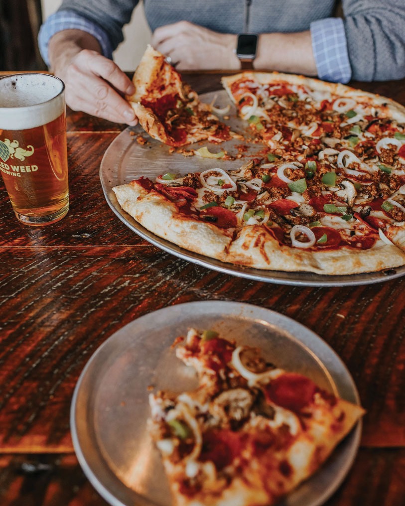 person eating pizza at Mojo Pizza