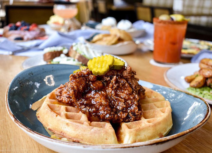 Nashville style hot chicken over Belgian waffle with pickles at Scout