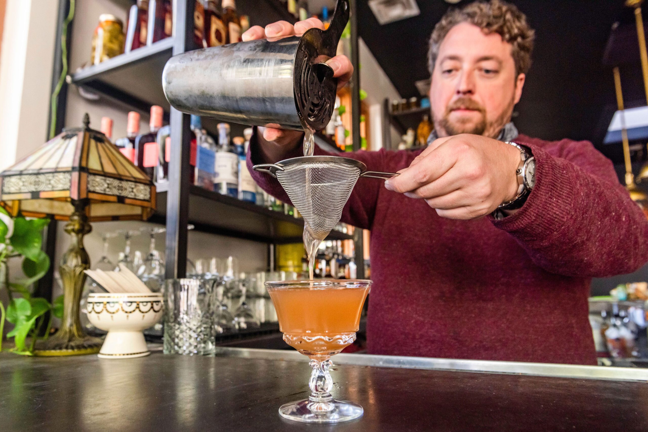 bartender strains drink at The Deer and The Dove