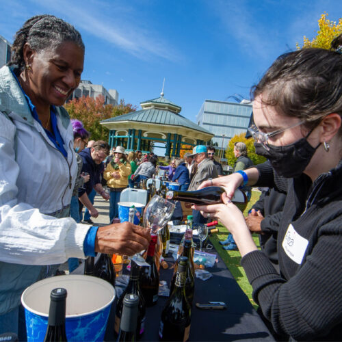 woman pouring wine into tasting glass outside on the downtown square at the Decatur Wine Festival