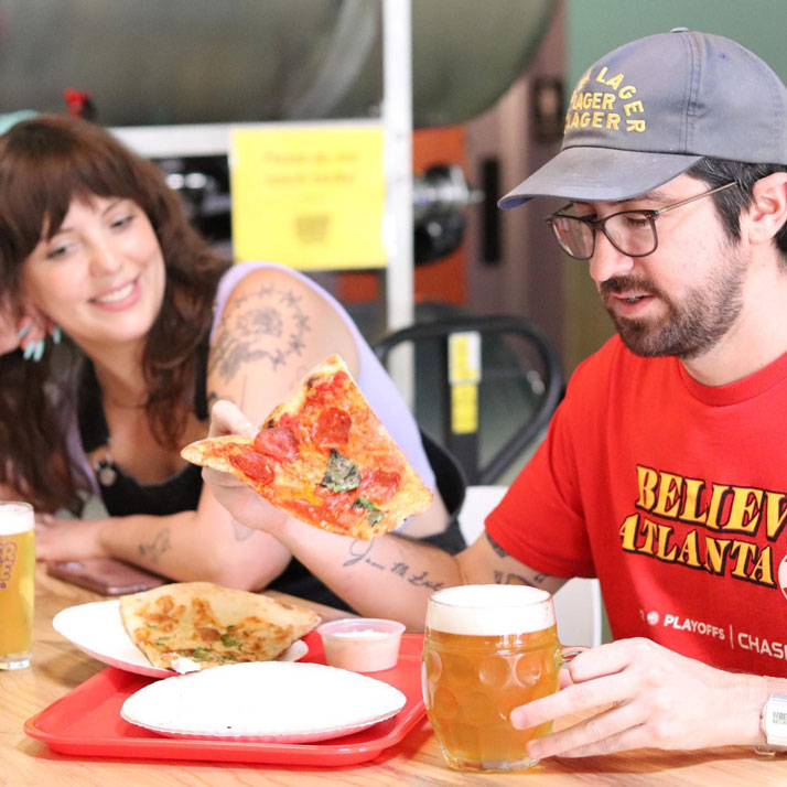 man eating Glide Pizza at Inner Voice Brewing