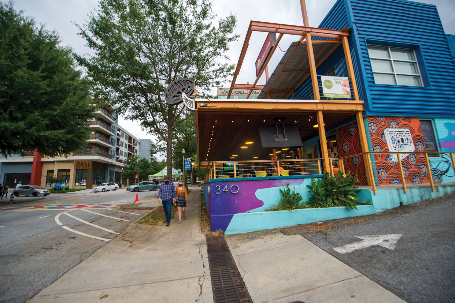 Mellow Mushroom restaurant exerior with painted mural and a couple walking down sidewalk